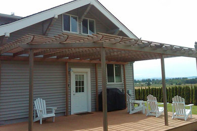 Deck - large craftsman backyard deck idea in Portland with a pergola