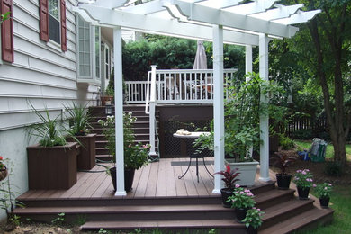 Diseño de terraza minimalista de tamaño medio en patio trasero con pérgola