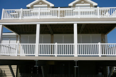 Example of a mid-sized beach style backyard deck design in Wilmington with a roof extension