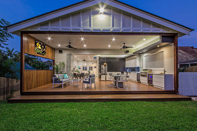 This is an example of a contemporary back terrace in Brisbane with an outdoor kitchen and a roof extension.