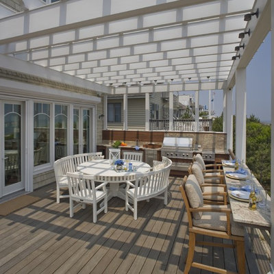 Large beach style backyard outdoor kitchen deck photo in Philadelphia with a pergola