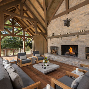Immagine di una terrazza country dietro casa con un caminetto e un tetto a sbalzo