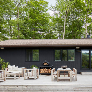 Idee per una grande terrazza nordica dietro casa con un tetto a sbalzo