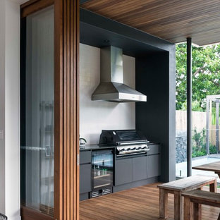 Ispirazione per una terrazza design di medie dimensioni e dietro casa con un tetto a sbalzo