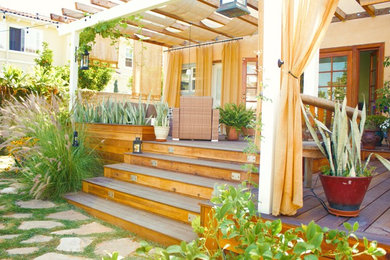 Ejemplo de terraza clásica de tamaño medio en patio trasero con jardín de macetas y toldo