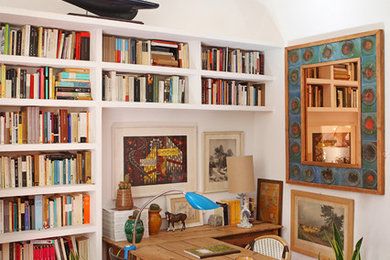 Inspiration för ett litet medelhavsstil hemmabibliotek, med vita väggar och ett fristående skrivbord