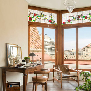 Imagen de despacho mediterráneo, de tamaño medio, con paredes beige, suelo de madera oscura, suelo marrón y escritorio independiente