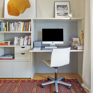 Kleines Modernes Arbeitszimmer ohne Kamin mit Arbeitsplatz, beiger Wandfarbe, Einbau-Schreibtisch, braunem Holzboden und orangem Boden in Barcelona