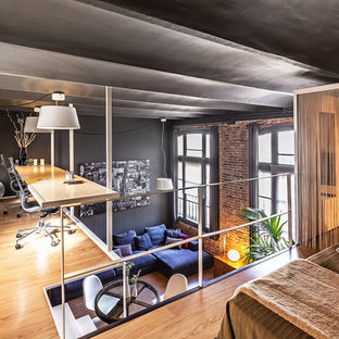 Diseño de despacho contemporáneo con paredes grises, suelo de madera clara, escritorio empotrado y suelo beige