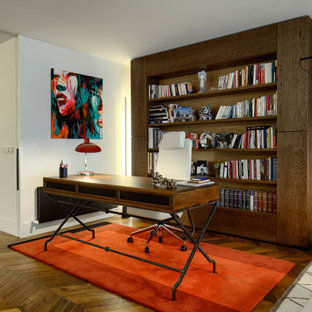 Idéer för ett mellanstort modernt hemmabibliotek, med röda väggar, mörkt trägolv, ett fristående skrivbord och brunt golv