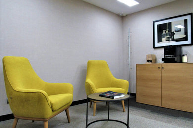 Imagen de despacho de tamaño medio con paredes grises, moqueta, escritorio independiente y suelo marrón