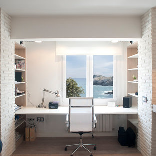 Diseño de estudio marinero, de tamaño medio, sin chimenea, con paredes blancas, suelo laminado, escritorio empotrado y suelo beige