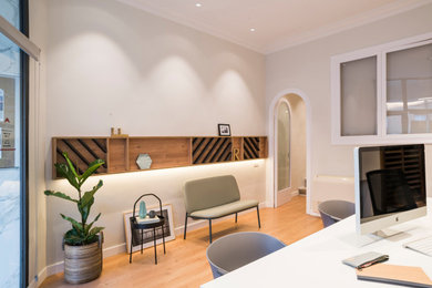 Ejemplo de despacho ecléctico de tamaño medio con paredes beige y suelo de madera en tonos medios