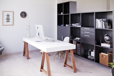 Imagen de despacho moderno de tamaño medio con paredes blancas, suelo de madera clara y escritorio independiente