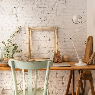 Bild på ett litet shabby chic-inspirerat hemmabibliotek, med vita väggar, betonggolv och ett fristående skrivbord
