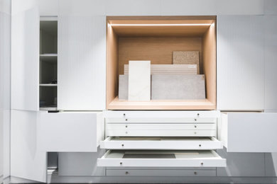Modelo de despacho nórdico pequeño con paredes blancas, moqueta, escritorio independiente y suelo gris