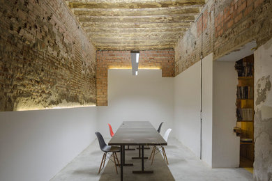 Diseño de despacho industrial de tamaño medio con biblioteca, suelo de cemento, escritorio independiente y suelo gris