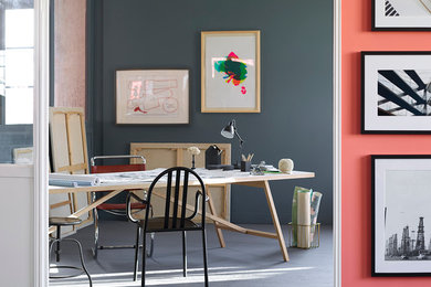 Modelo de estudio ecléctico con paredes grises, suelo de madera en tonos medios y escritorio independiente