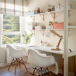 Idéer för mellanstora vintage hemmabibliotek, med beige väggar, mellanmörkt trägolv, brunt golv och ett fristående skrivbord