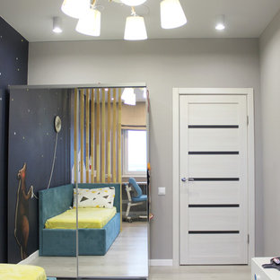 Esempio di una cameretta da bambino da 4 a 10 anni scandinava di medie dimensioni con pareti grigie, pavimento in laminato e pavimento beige