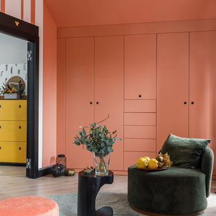 Foto di una cameretta per bambini da 4 a 10 anni design di medie dimensioni con pavimento in laminato e pareti rosa