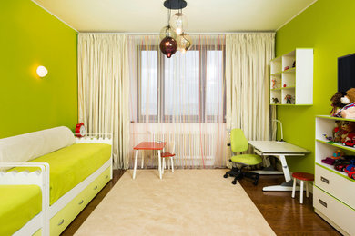 Diseño de habitación infantil unisex de 4 a 10 años actual con paredes verdes y suelo de madera en tonos medios