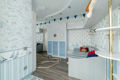 Ejemplo de dormitorio infantil de 4 a 10 años costero con paredes azules y suelo de madera en tonos medios