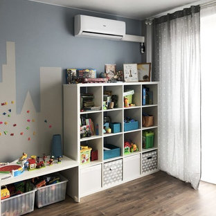 Foto di una cameretta per bambini da 4 a 10 anni nordica di medie dimensioni con pareti blu, pavimento in laminato e pavimento marrone
