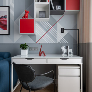 Cette image montre une chambre de garçon de 4 à 10 ans traditionnelle de taille moyenne avec un bureau, un mur gris, sol en stratifié et un sol beige.