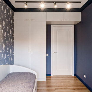 Foto di una piccola cameretta da bambino da 4 a 10 anni contemporanea con pareti blu, pavimento in laminato, pavimento giallo e carta da parati