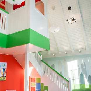Immagine di un'ampia cameretta per bambini da 4 a 10 anni minimal con pareti multicolore, pavimento in legno massello medio e pavimento marrone