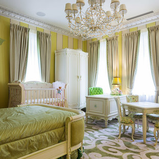 Immagine di un'ampia cameretta per bambini da 1 a 3 anni tradizionale con pareti verdi e parquet chiaro