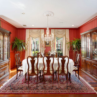 Enclosed dining room - mid-sized traditional medium tone wood floor and brown floor enclosed dining room idea in Other with red walls and no fireplace