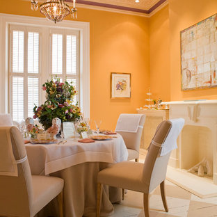 Ispirazione per una sala da pranzo aperta verso il soggiorno chic di medie dimensioni con pavimento in legno verniciato, camino classico, cornice del camino in intonaco e pareti gialle