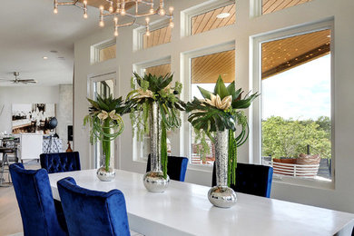 Exemple d'une salle à manger ouverte sur la cuisine tendance de taille moyenne avec un mur blanc, parquet clair et aucune cheminée.