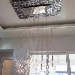 Réalisation d'une grand salle à manger ouverte sur la cuisine minimaliste avec un mur blanc et un sol en marbre.