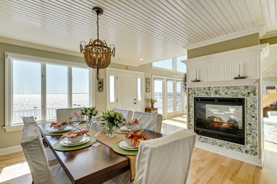 Large beach style light wood floor kitchen/dining room combo photo in New York with beige walls, a two-sided fireplace and a stone fireplace