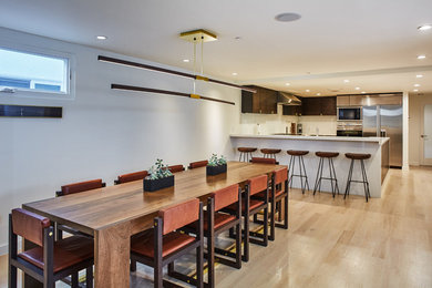 Mittelgroße Moderne Wohnküche ohne Kamin mit weißer Wandfarbe und hellem Holzboden in Los Angeles