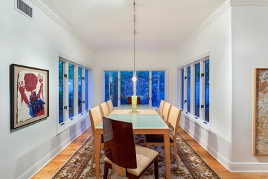 Foto di una grande sala da pranzo chiusa con pareti bianche, pavimento in legno massello medio e pavimento arancione