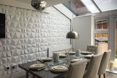 Réalisation d'une salle à manger design avec un mur blanc, parquet clair et un sol beige.