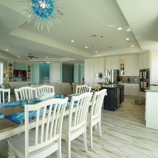Immagine di una sala da pranzo aperta verso il soggiorno stile marinaro di medie dimensioni con pareti blu, pavimento in gres porcellanato e nessun camino