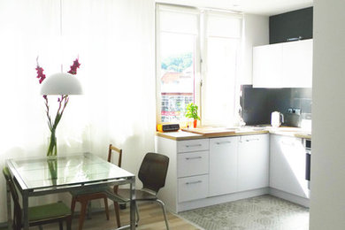 Imagen de comedor de cocina escandinavo pequeño con paredes blancas y suelo de madera clara