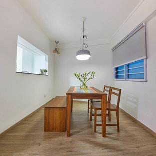 Idée de décoration pour une salle à manger nordique fermée et de taille moyenne avec un mur blanc et un sol en contreplaqué.