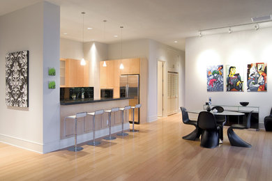 Foto di una sala da pranzo aperta verso la cucina moderna di medie dimensioni con pareti bianche, parquet chiaro e nessun camino