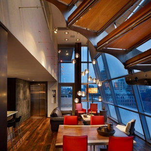 Idee per una piccola sala da pranzo aperta verso il soggiorno industriale con pareti beige, parquet scuro, nessun camino e pavimento marrone