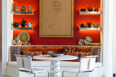 This is an example of an eclectic dining room in Miami with red walls, light hardwood flooring and no fireplace.