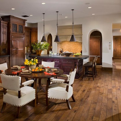 Example of a tuscan dark wood floor kitchen/dining room combo design in Orange County with white walls