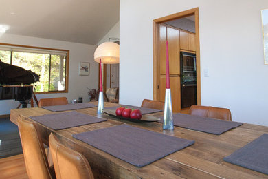 Imagen de comedor nórdico de tamaño medio abierto sin chimenea con paredes blancas, suelo de madera clara y suelo marrón