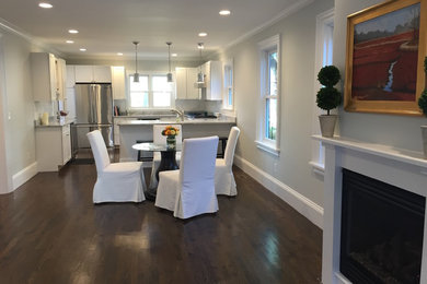Inspiration for a mid-sized transitional medium tone wood floor kitchen/dining room combo remodel in Boston with white walls, a standard fireplace and a wood fireplace surround
