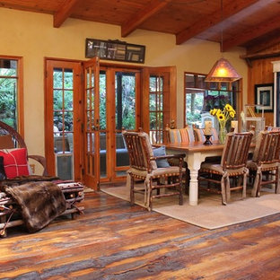 Esempio di una sala da pranzo stile rurale con pareti gialle, parquet scuro e pavimento marrone